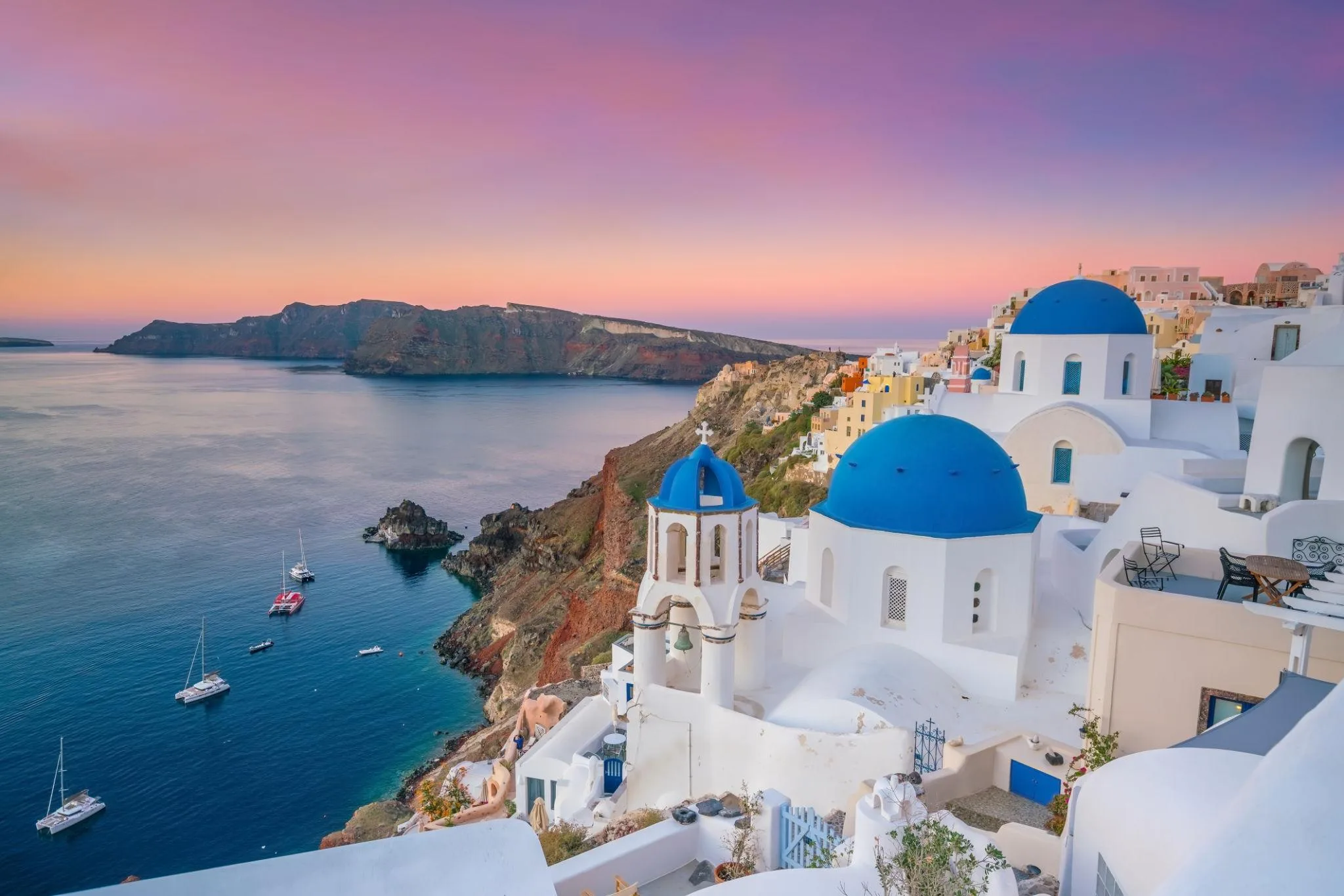 Whitewashed buildings and blue-domed churches overlooking the sea in Santorini, Greece